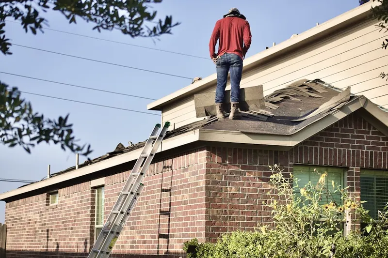 Professional roofer working on a residential roof in Ellwood City